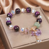 Close up of purple amethyst bracelet with crystal beads and gold money bag charm