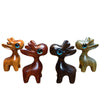 Four small wooden deer charms lined up showing different wood colors and blue eyes