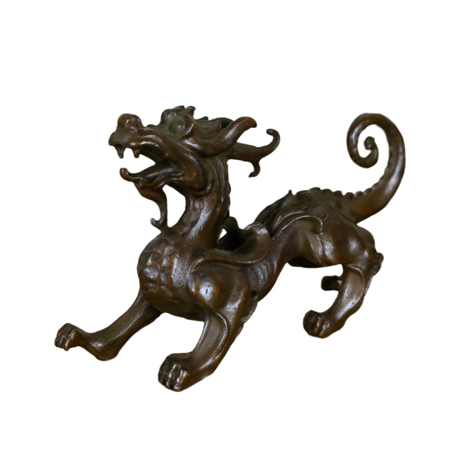 Side view of a dark bronze alloy Pixiu statue on a wooden surface