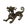 Side view of a dark bronze alloy Pixiu statue on a wooden surface