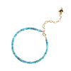 Close-up of a blue faceted crystal bracelet with a gold-tone heart charm on the extension chain