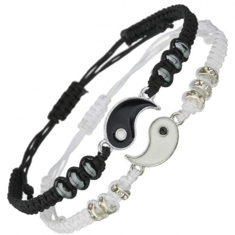 Pair of black and white woven bracelets with silver Yin Yang charms