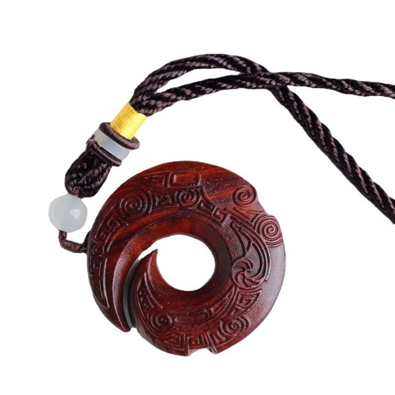 Close up of carved red sandalwood crescent pendant necklace