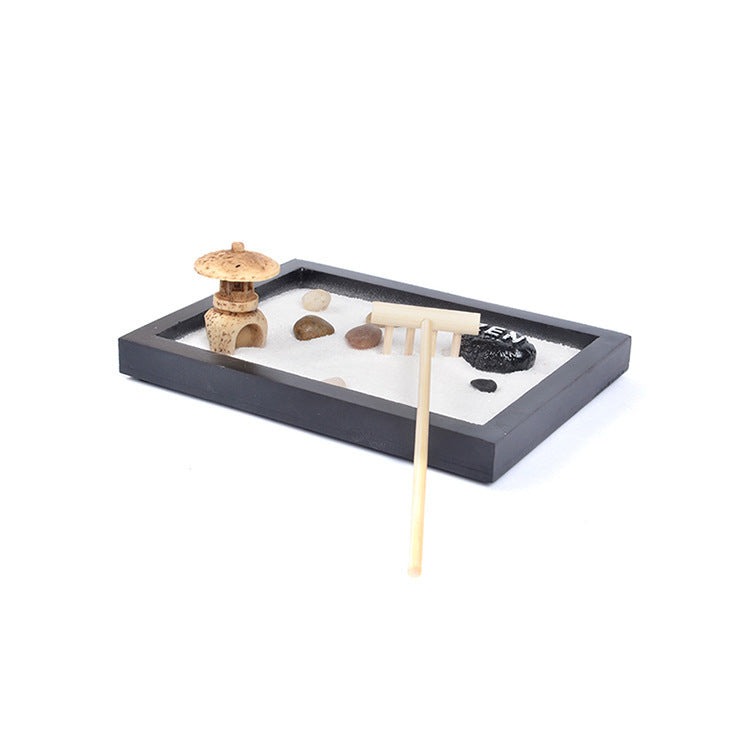 Small rectangular zen garden tray with white sand, stones, and a wooden rake tool