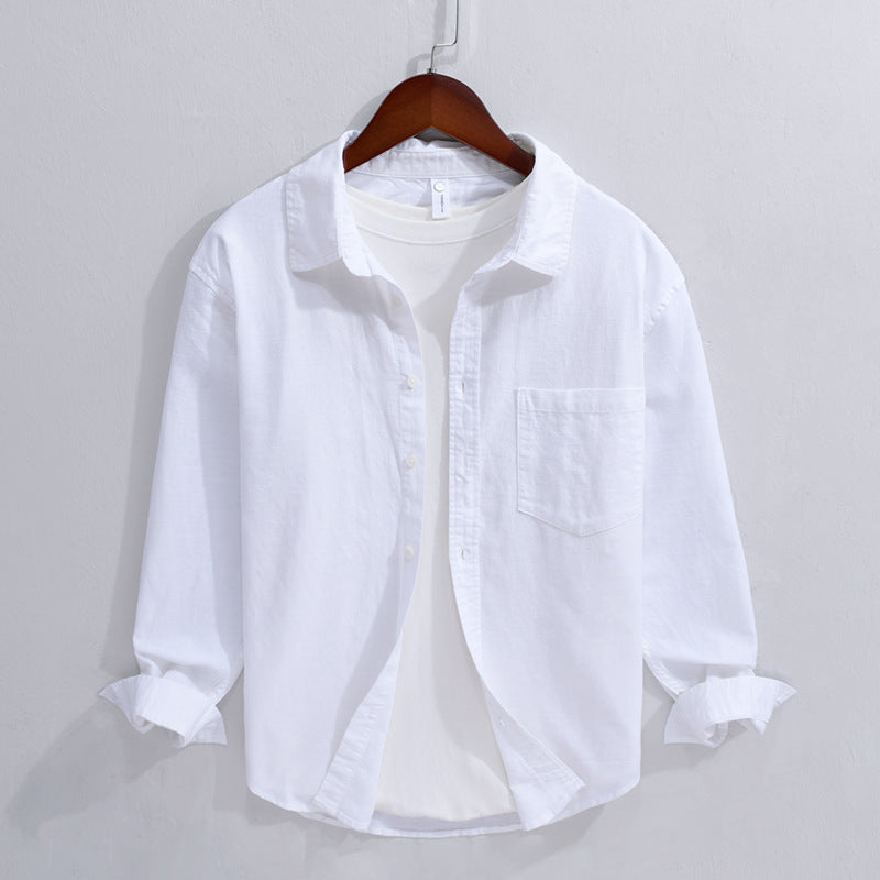 White men's long sleeve linen shirt with turn-down collar hanging on a wooden hanger