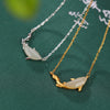 White jade dolphin pendant necklace in gold and silver tones