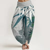 Woman wearing loose grey harem pants with green bamboo leaf print