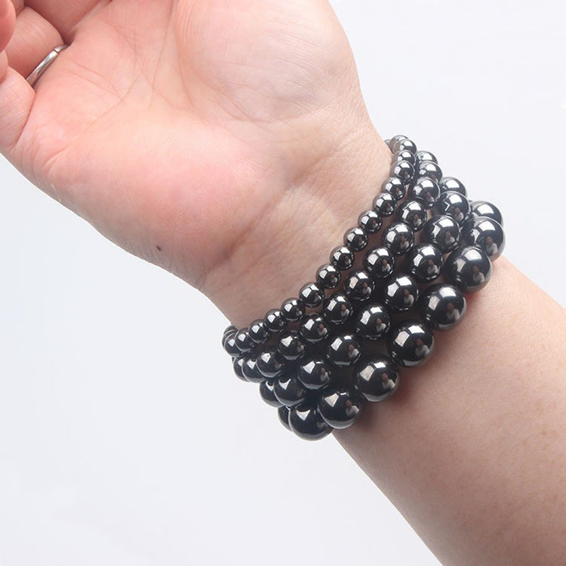 Close-up of a black polished stone bead bracelet on a wrist