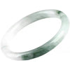 Close up of a thin jade bracelet bangle with green and white coloring on a wooden table