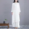Woman wearing a white long sleeve midi dress and wide leg pants standing in a studio