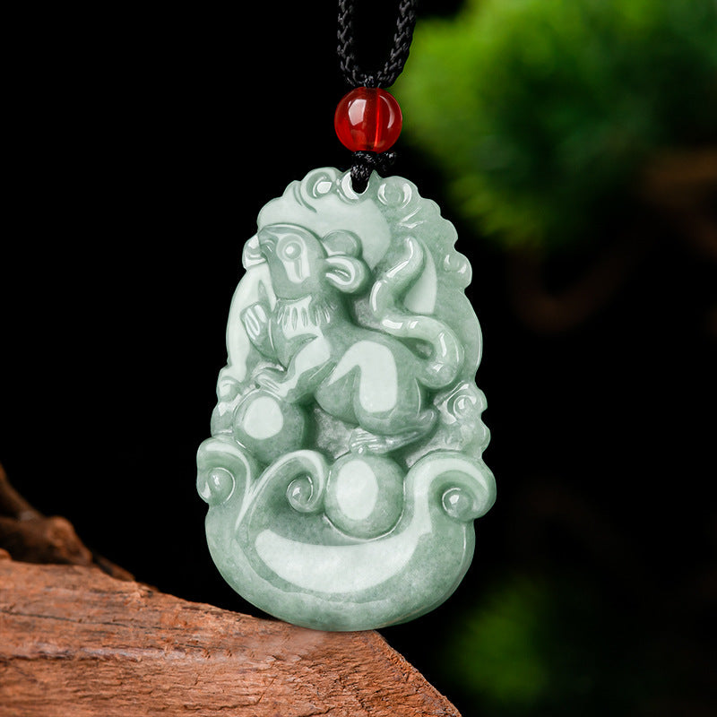 Close up view of a carved light green jade pendant showing a monkey design on a dark background