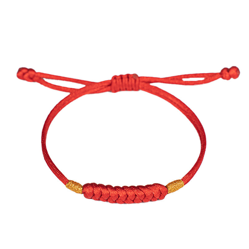 Close up of a red braided cord bracelet with gold accents on a white background