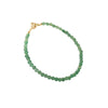 Close-up of a thin green aventurine beaded bracelet on a wrist