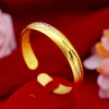 Gold-tone open cuff bracelet with feather pattern and engraved inner text