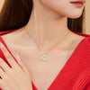A woman wearing a pale green jade pendant necklace with a gold snake design on a silver chain.
