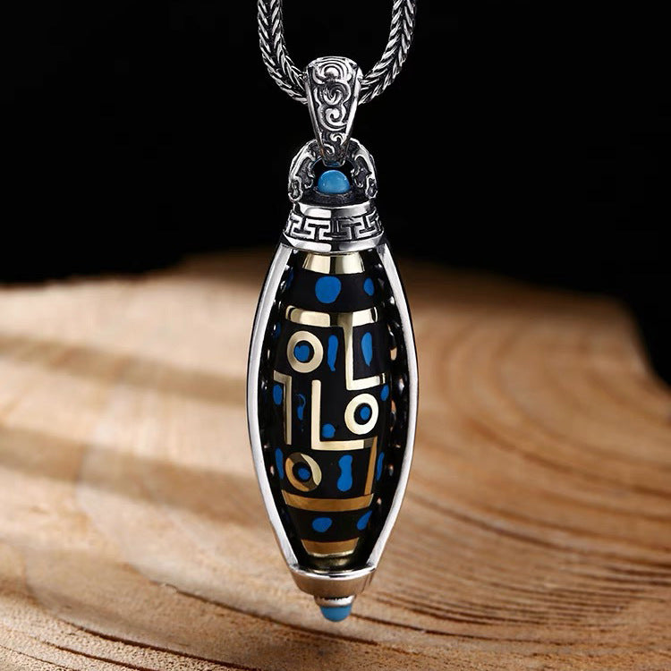 Close up of a silver plated rotatable pendant with blue Dzi patterns