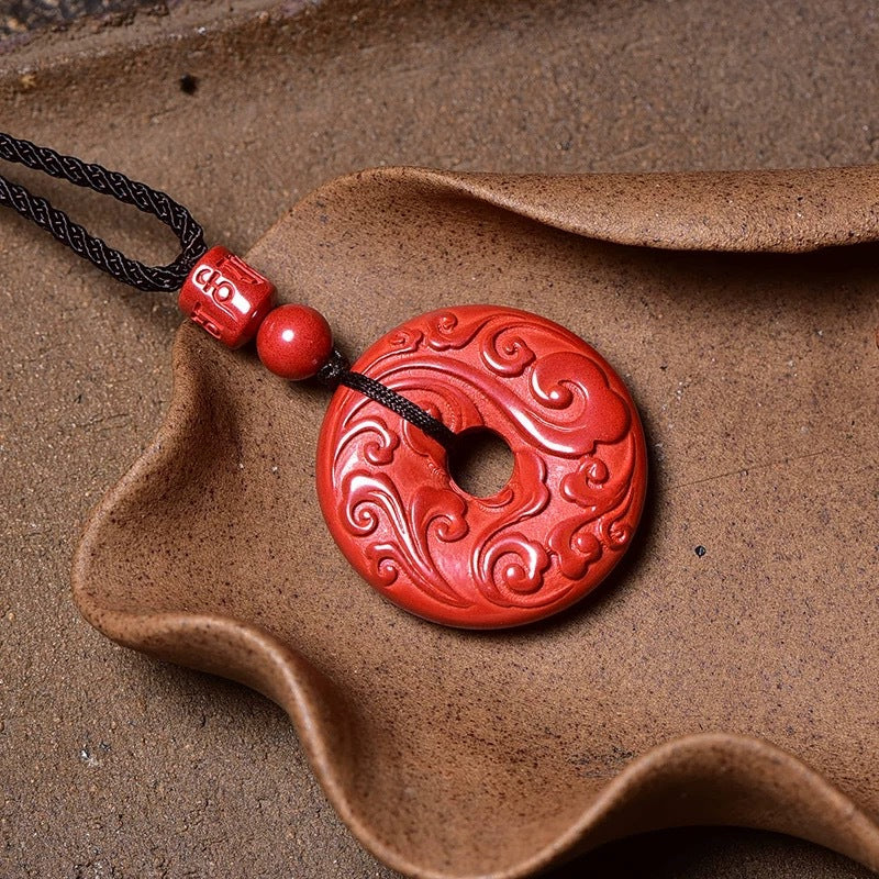 Red cinnabar peace buckle pendant with a carved return pattern on a black cord