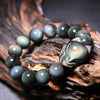 Close up view of a rainbow obsidian beaded bracelet with a carved fox charm