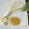 Close up of a yellow aventurine keychain with the number 888 engraved in gold.