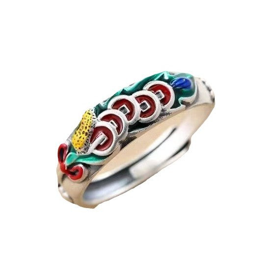 Close up of an enamel ring with five red and gold coins on a silver tone band