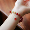 Red agate and white jade beaded bracelet with a rabbit charm on a wrist