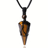 Close up of a brown tiger eye hexagonal pendant wrapped in black cord on a necklace
