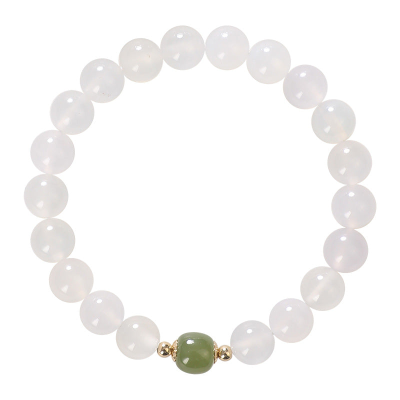 Close up of a white agate beaded bracelet with a green jade charm