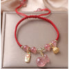 Braided red string bracelet with pink strawberry quartz beads and gold charms