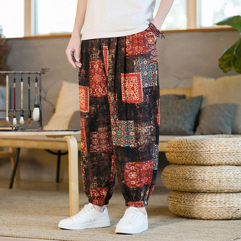 Man wearing colorful patchwork harem pants standing indoors