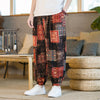 Man wearing colorful patchwork harem pants standing indoors