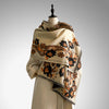 Beige scarf with brown and orange floral patterns draped on a mannequin