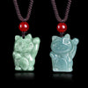 Two jade lucky cat pendants on cords, one bean green and one blue water
