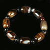 Brown banded agate barrel bead bracelet with black spacers on a dark background