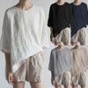 Model wearing a white loose fit cotton linen t-shirt with short sleeves and an asymmetrical hem