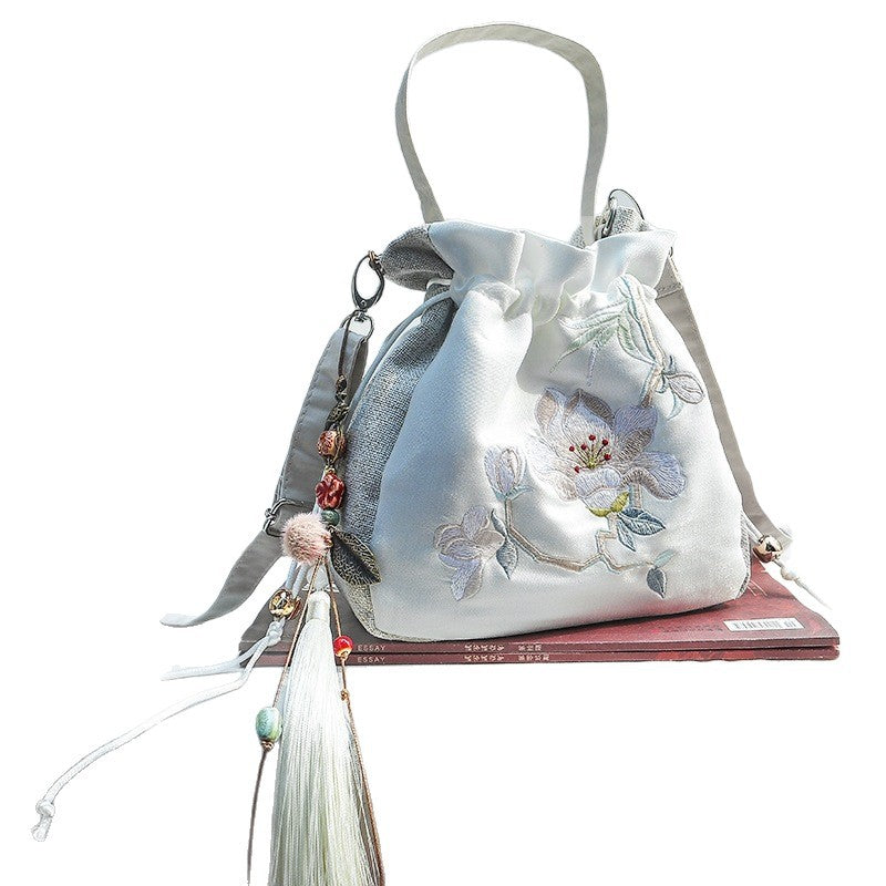 White velvet bucket bag with magnolia embroidery and tassel charm