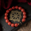 Red carved sand beads with a black ebony center bead on a dark surface