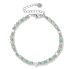 Silver-tone bracelet with light green stone beads and a heart charm on a white background
