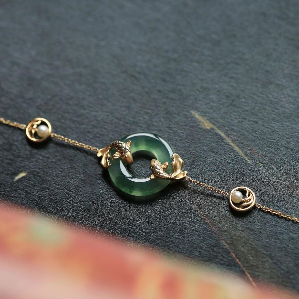 Gold tone bracelet with green peace buckle and koi fish on dark background