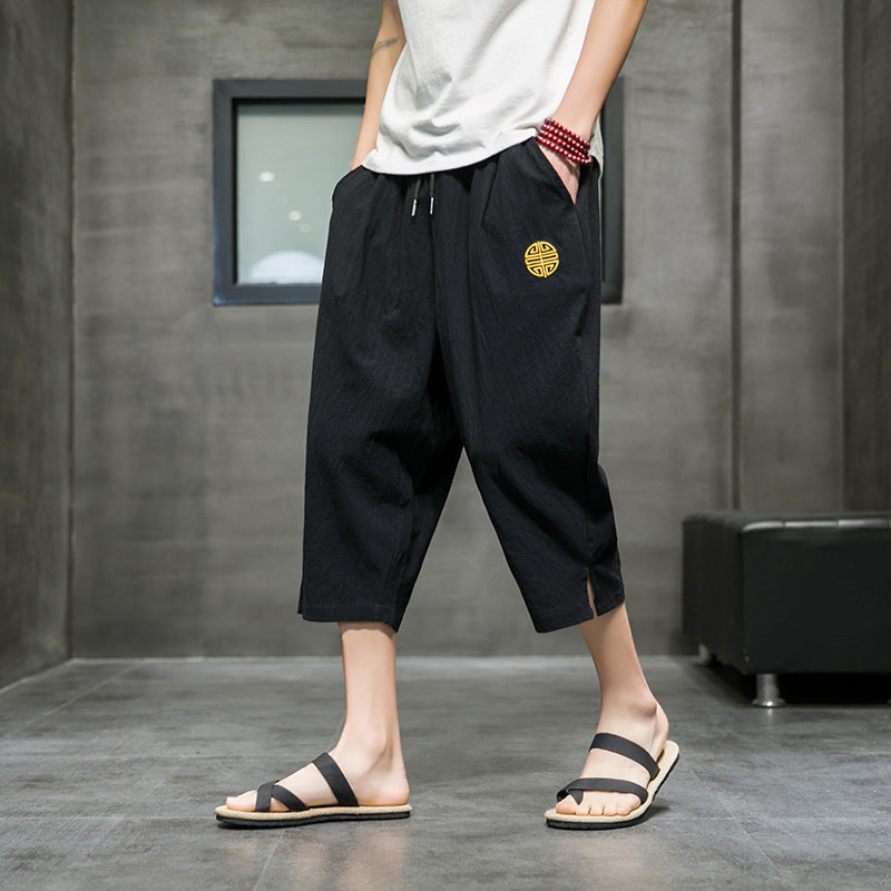 Man wearing navy blue cropped pants with a drawstring waist and side pockets.