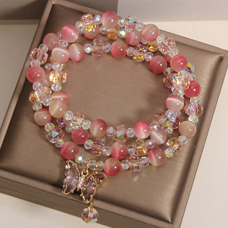 Triple wrap bracelet with pink cat's eye beads and a butterfly charm