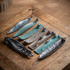 Collection of ceramic incense holders in shapes like a hand, leaf, and bamboo on a wooden tray