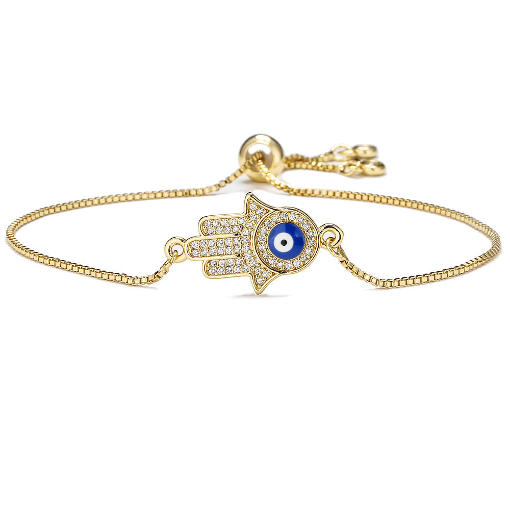 Gold tone copper bracelet with Hamsa hand and blue evil eye charm