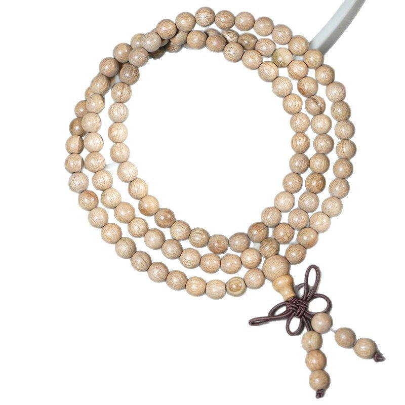 Coiled camphor wood mala necklace with 108 beads on a red background