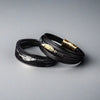 Black multilayer leather bracelet with a silver feather charm and magnetic clasp