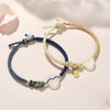 Two woven string bracelets with white agate peace buckles on a light surface