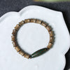 Green sandalwood bamboo joint bracelet with a green Dzi bead on a white dish