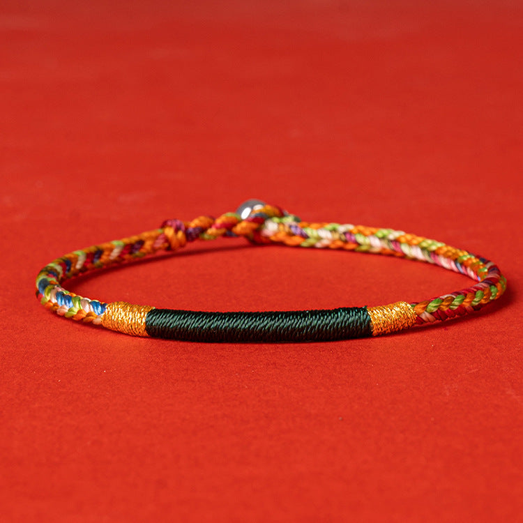 Close up of a multicolored hand-woven bracelet on a red background