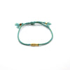 Teal braided rope bracelet with a gold-tone copper koi fish charm and adjustable sliding knots