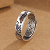 A silver-toned copper ring with a blue koi fish and red cloud design on a brown background.