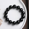 Faceted natural black onyx bracelet resting on a white ceramic dish